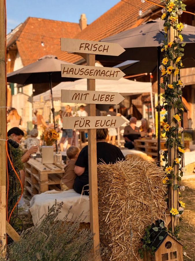 Holzwegweiser mit den Schildern Frisch, Hausgemacht, Mit Liebe, Für euch.